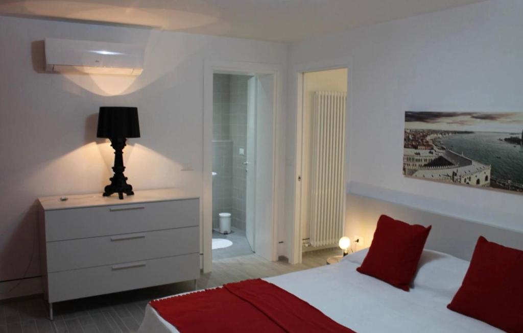 a bedroom with a bed and a dresser with a lamp at MONNALISA VENICE APARTMENT in Venice