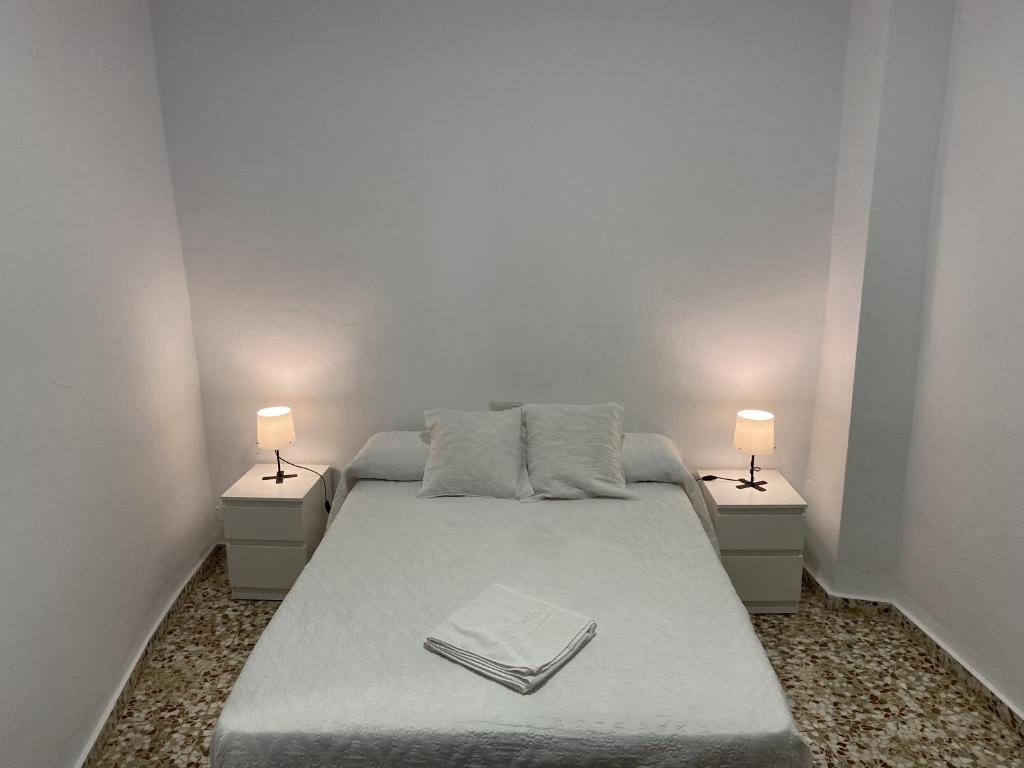 a bedroom with a bed with two lamps on it at Casa Pepe La Rosa in Tolox