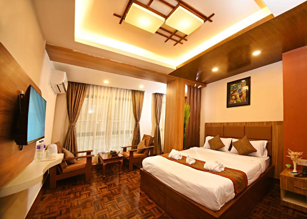 a bedroom with a bed and a living room at Capital Boutique Hotel in Kathmandu