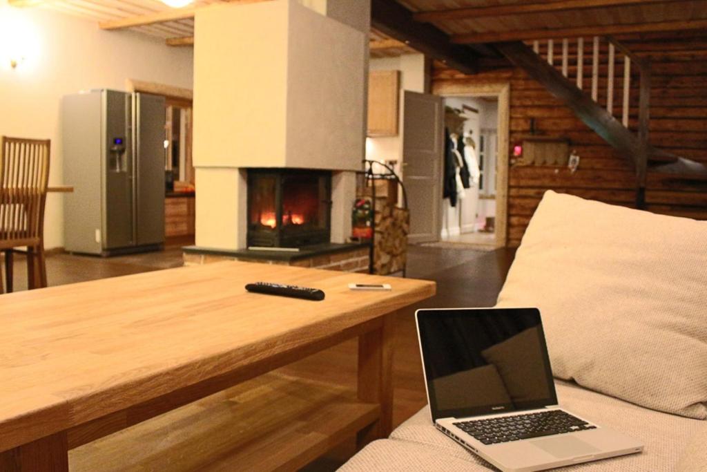 a laptop sitting on a couch in a living room with a fireplace at Kalurikodu Holiday Home in Kärdla