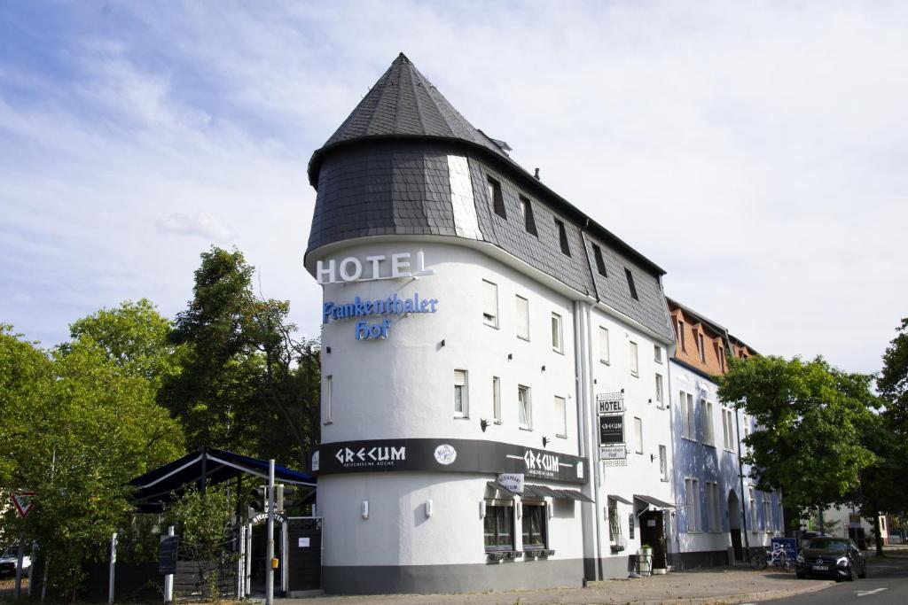 a white hotel with a black roof on a street at Hotel Frankenthaler Hof in Frankenthal