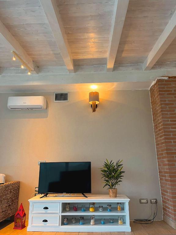 un salon avec une télévision à écran plat sur un mur dans l'établissement Cottage indipendente con piscina privata, à Masi San Giacomo