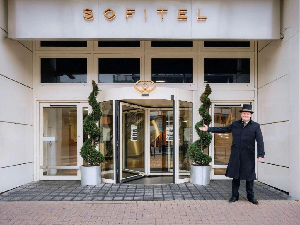 ホーリーにあるソフィテル ロンドン ガトウィックの建物前に立つ男