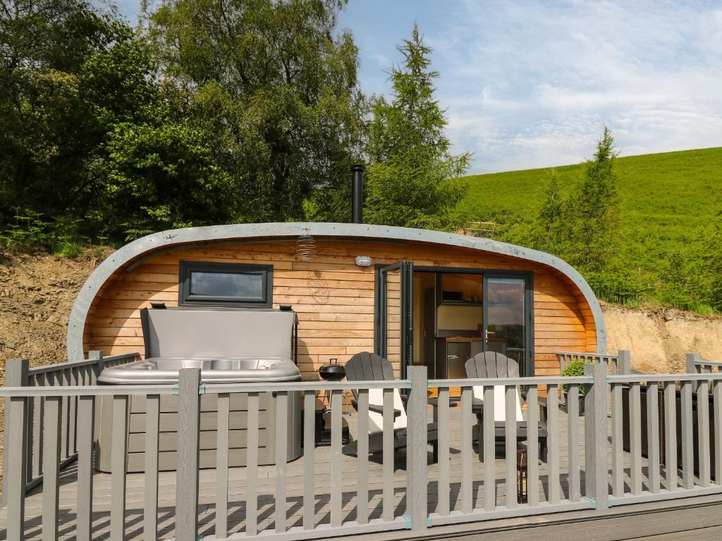 a small cabin with a laptop on a deck at Beacon View Pod in Knighton