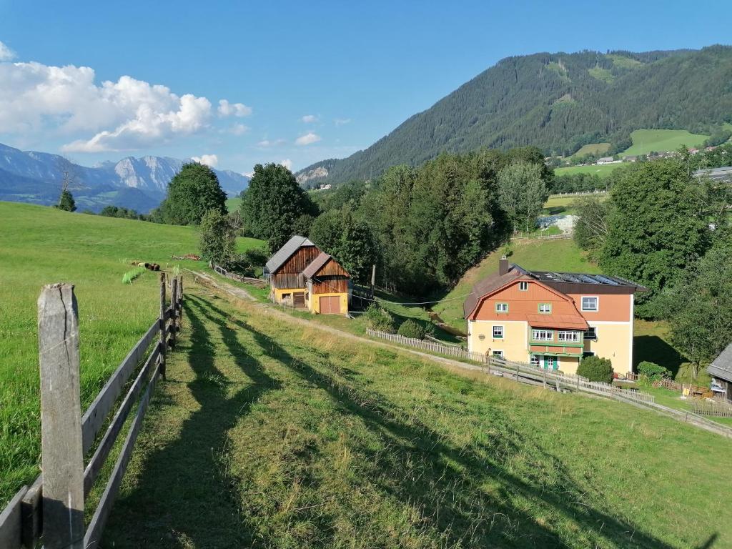 a fence in a field with houses and mountains at Ferienwohnung Weppermühle 