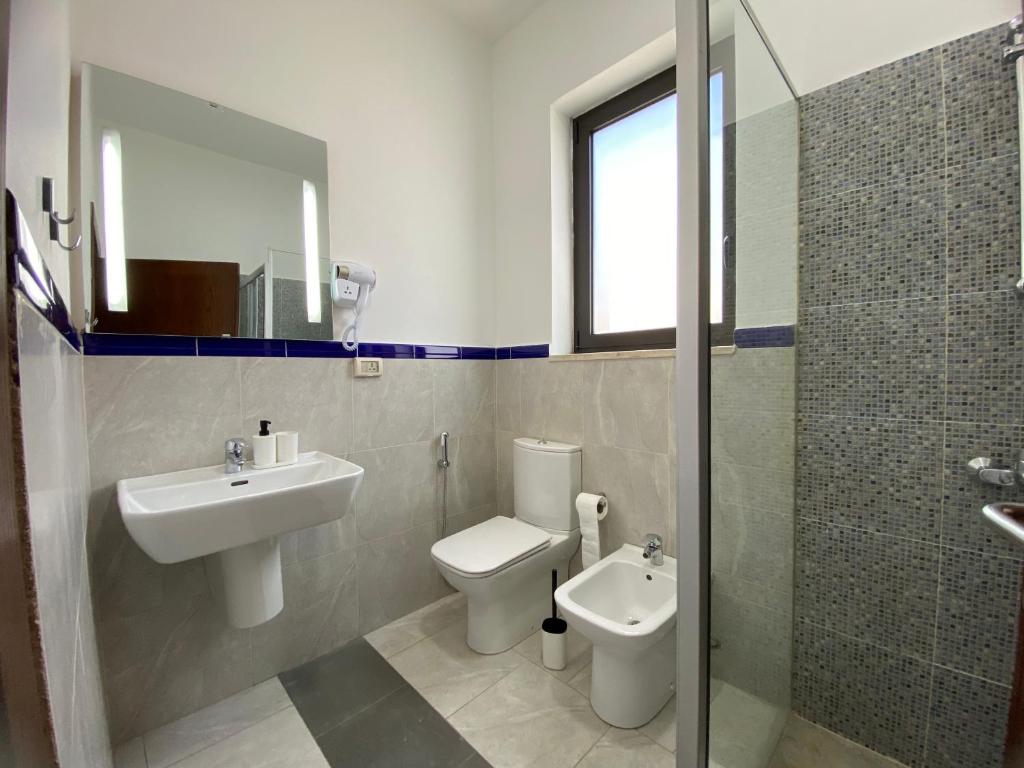 a bathroom with a sink and a toilet and a shower at Lemon Tree Residence in Amman