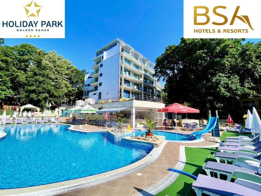 a large swimming pool with chairs and a building at BSA Holiday Park Hotel - All Inclusive in Golden Sands