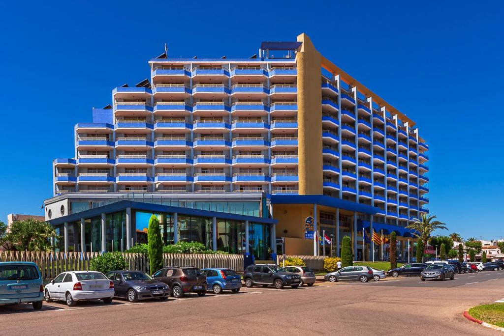 a large building with cars parked in front of it at Xon's Platja HA in Empuriabrava