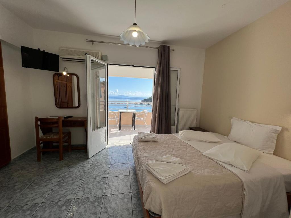 sypialnia z łóżkiem i widokiem na ocean w obiekcie Harbour View - Oceanis Apartments w mieście Poros