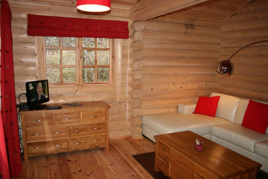 a living room with a couch and a table at BCC Loch Ness Log Cabins in Bearnock