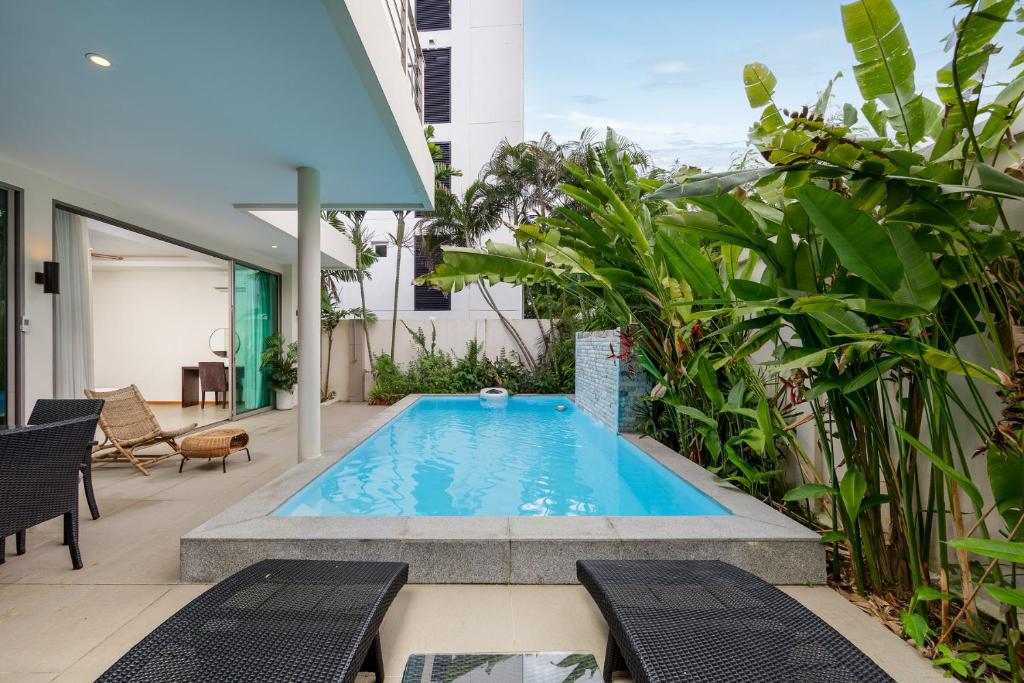 uma piscina no meio de um pátio com plantas em Ka Villas x GSG em Phuket