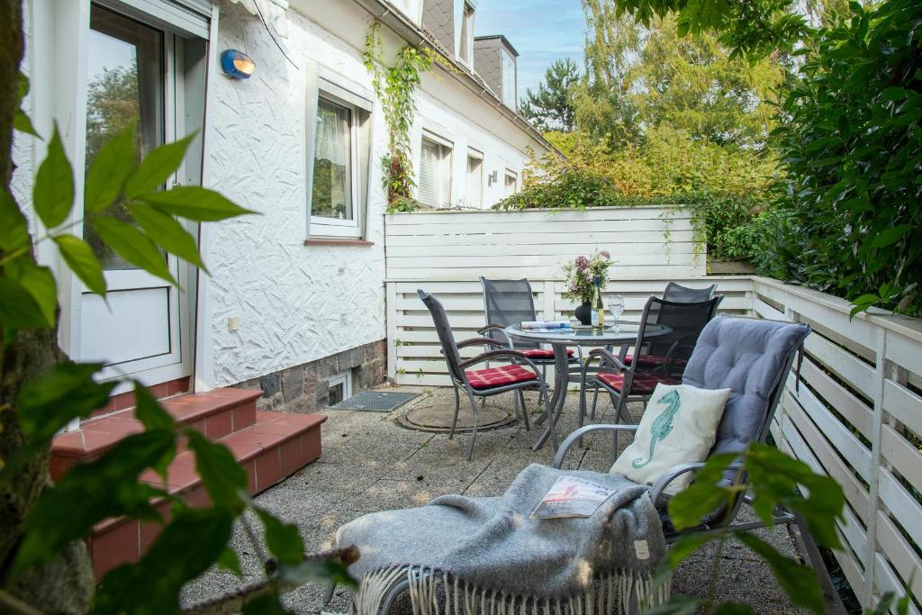 a patio with chairs and a table and a fence at Haus Sonnenberg in Timmendorfer Strand