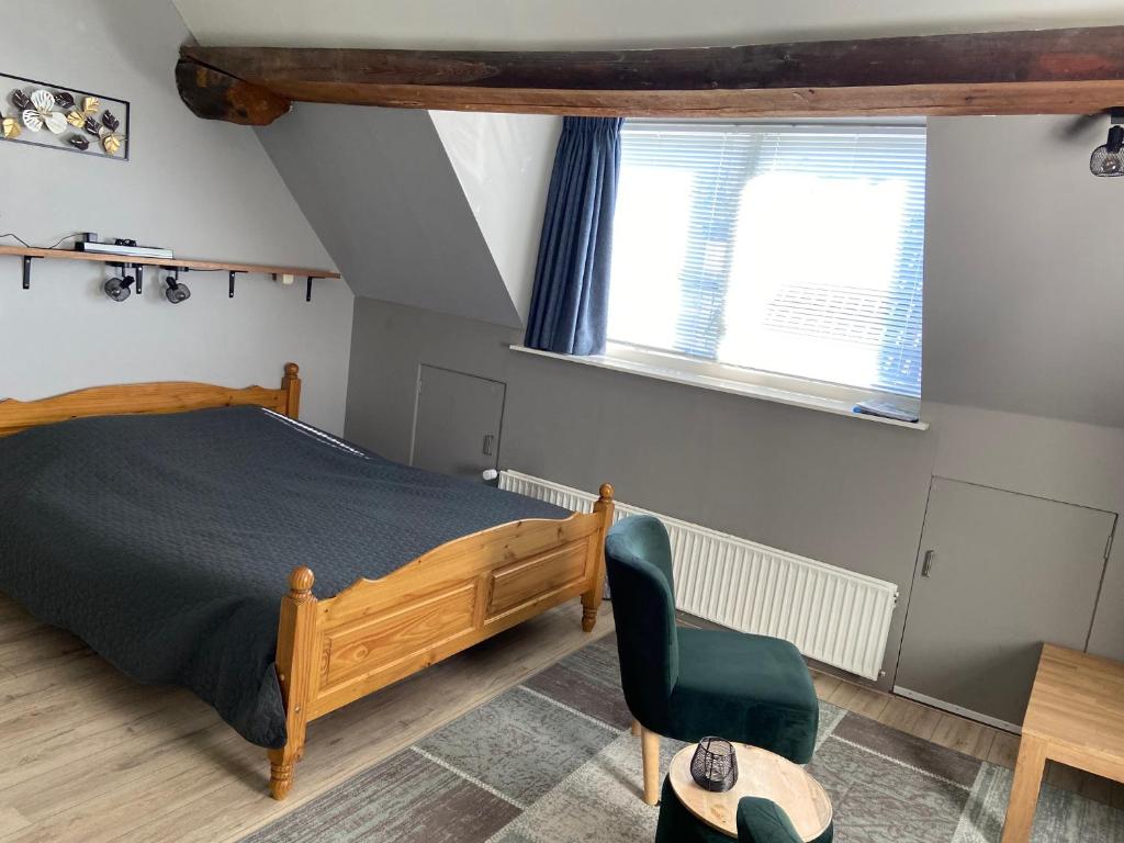 een slaapkamer met een bed en een stoel en 2 ramen bij De Posthoorn in Appelscha