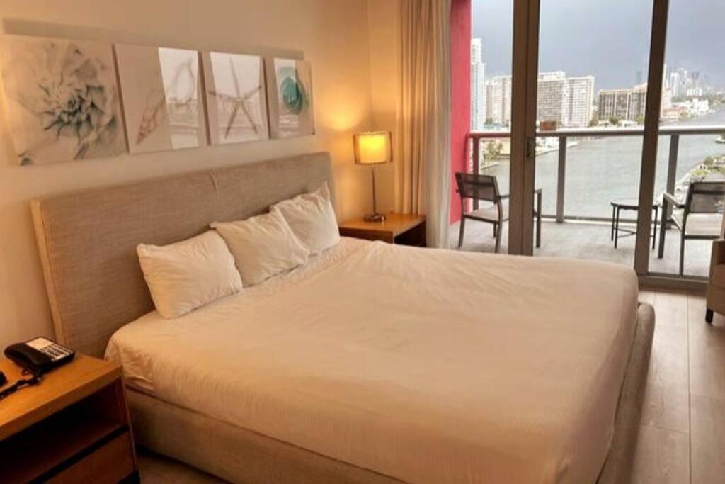 a hotel room with a bed and a view of the water at Amazing 1B-1B Apartment With Amazing View! in Hallandale Beach