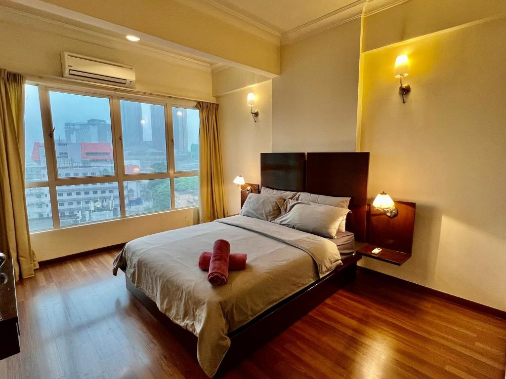 a bedroom with a bed with two red shoes on it at Casa Mutiara Apartments by Moonlight in Kuala Lumpur