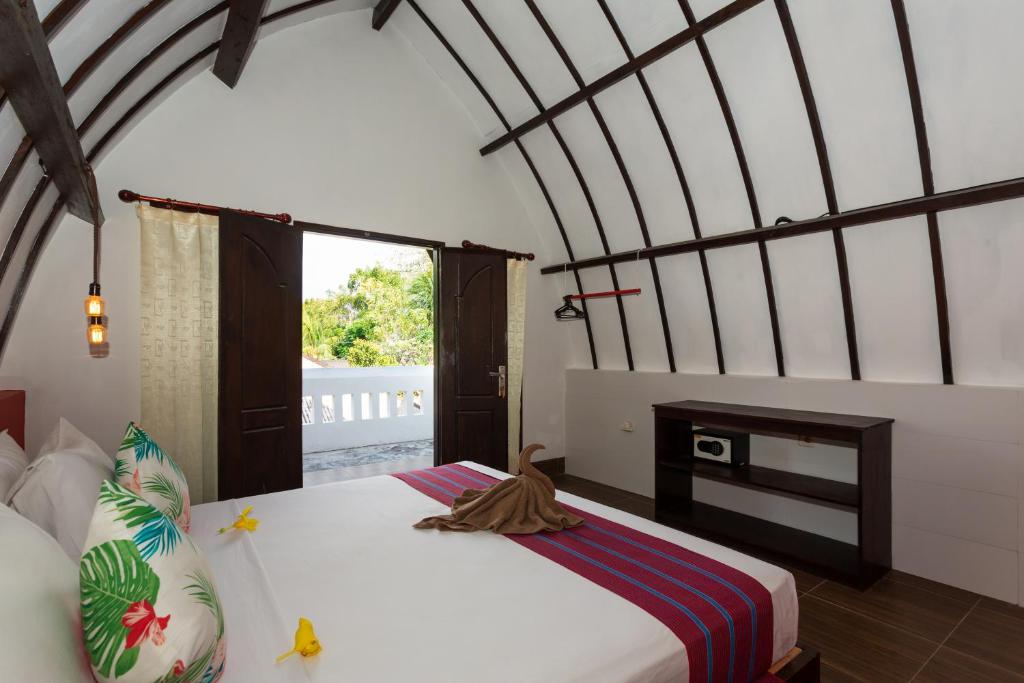 Postel nebo postele na pokoji v ubytování Kidi's Lodge Gilitrawangan