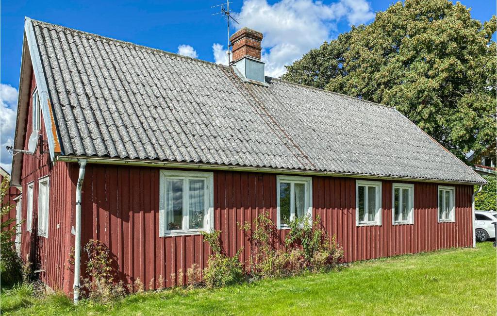 un granero rojo con una chimenea encima en Beautiful Home In Laholm With Kitchen en Laholm