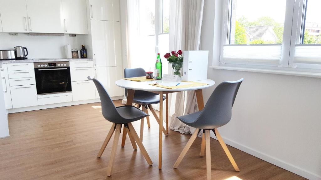 a kitchen with a table and four chairs at Ferienwohnung Trave - Wohlfühlatmosphäre zum Auftanken in Bad Oldesloe