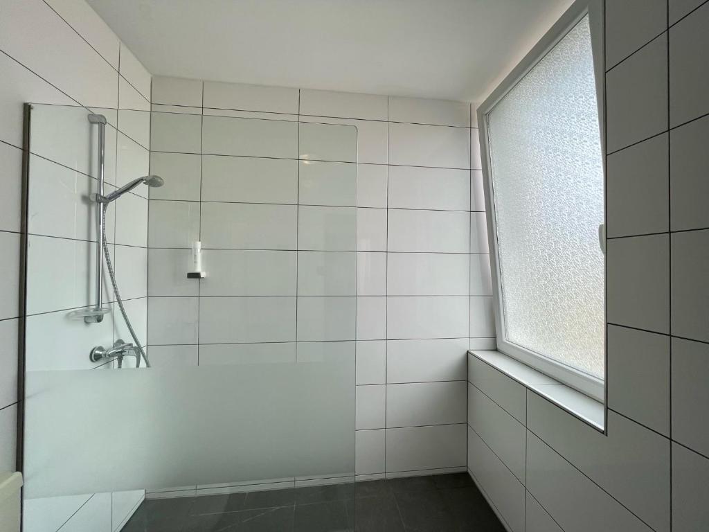 a white bathroom with a shower and a window at Hotel Residenz in Ansbach