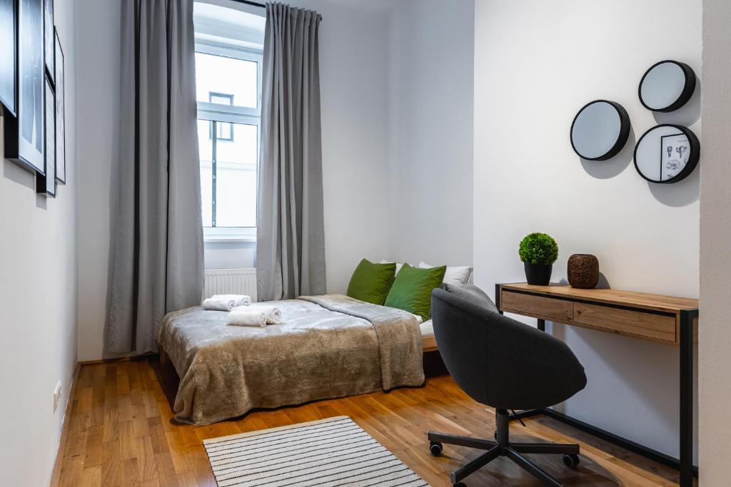 1 dormitorio con cama, escritorio y silla en Stylish designed apartment in a calm district en Viena