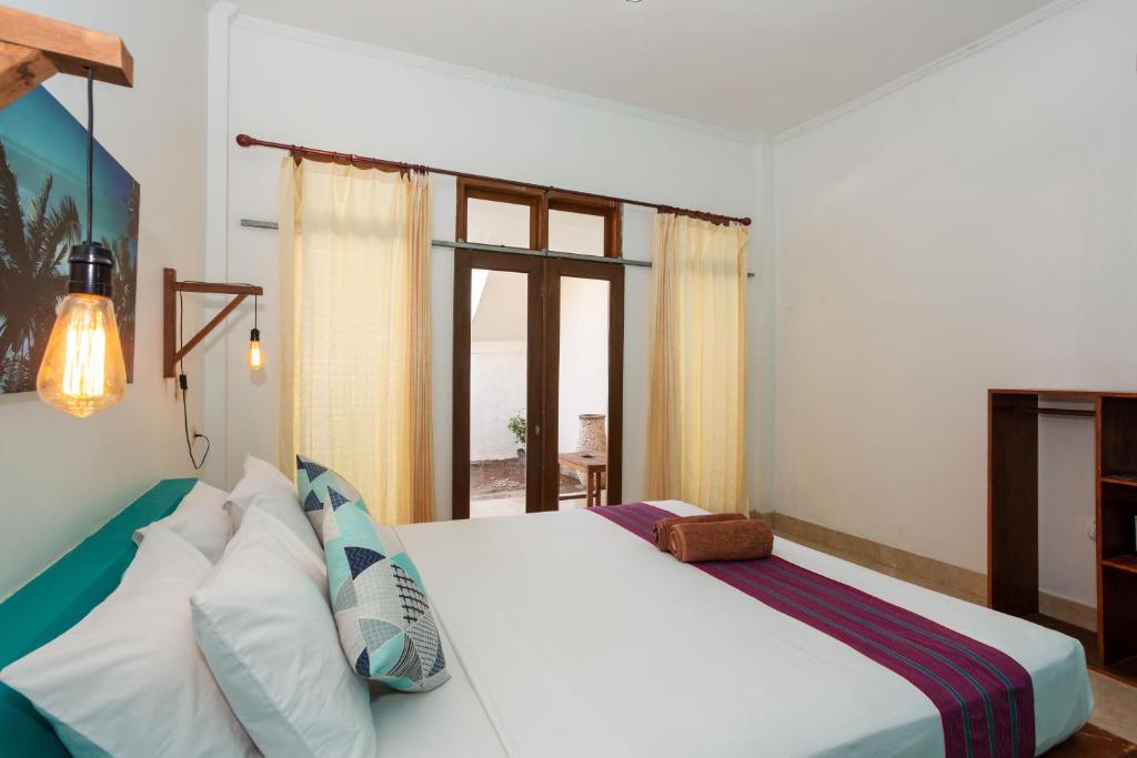 Postel nebo postele na pokoji v ubytování Kidi's Lodge Gilitrawangan