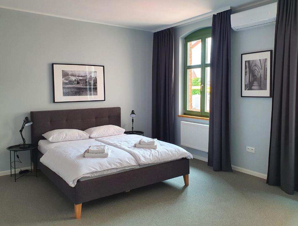 a bedroom with a bed with two towels on it at Apartamenty K17 in Malbork