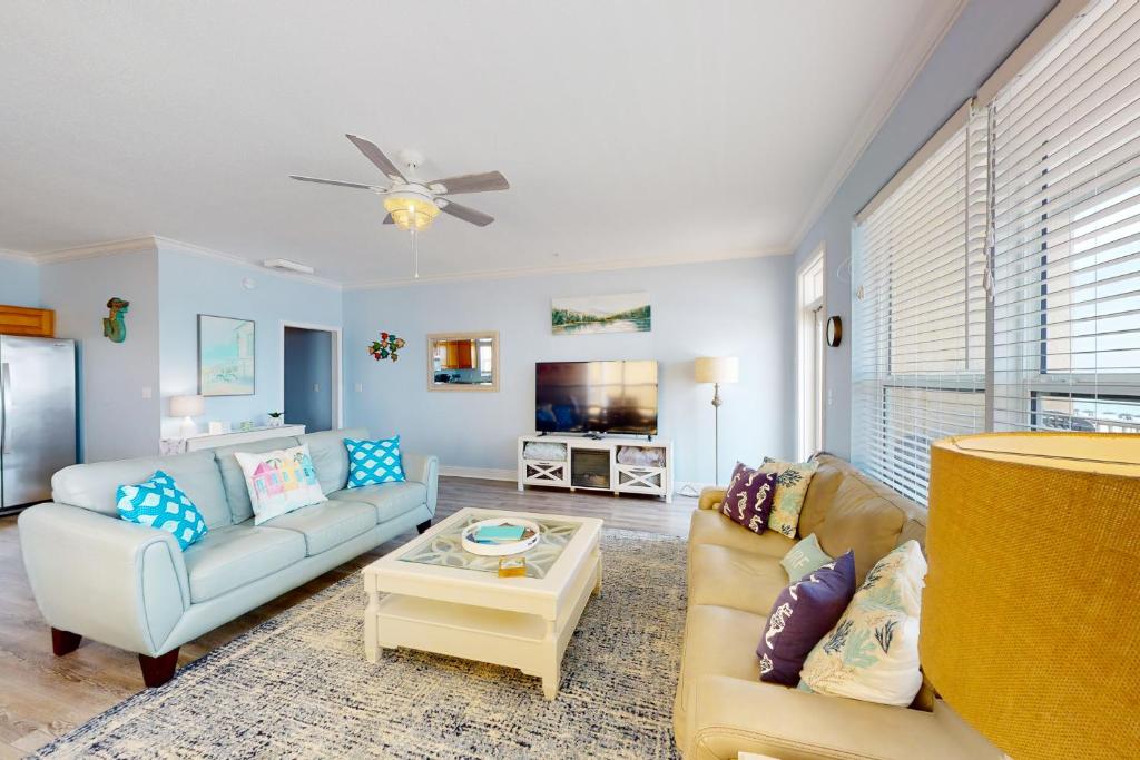 sala de estar con sofá y mesa en Blue Dolphin 301, en Fort Walton Beach