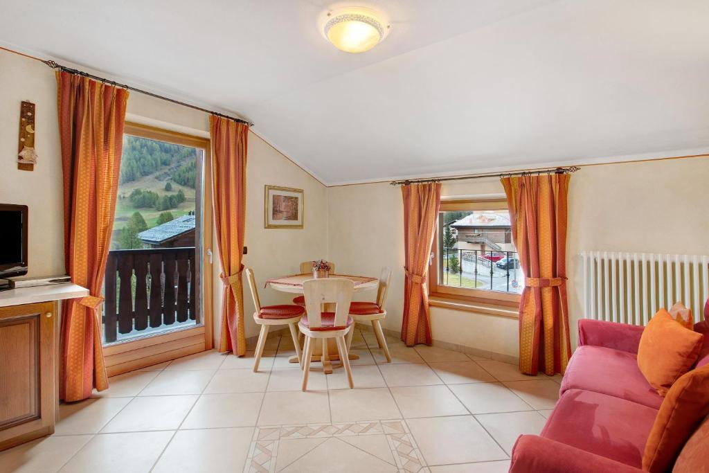 een woonkamer met een bank en een tafel en stoelen bij Baita Aris Appartamento Ables in Livigno