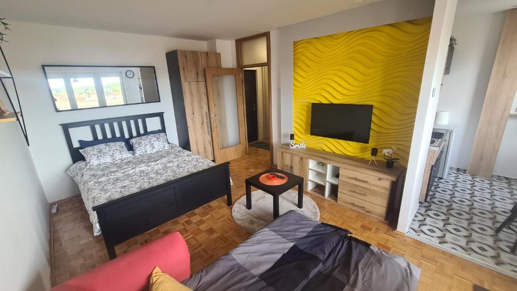 a living room with a bed and a tv at STUDIO 33 in Šabac