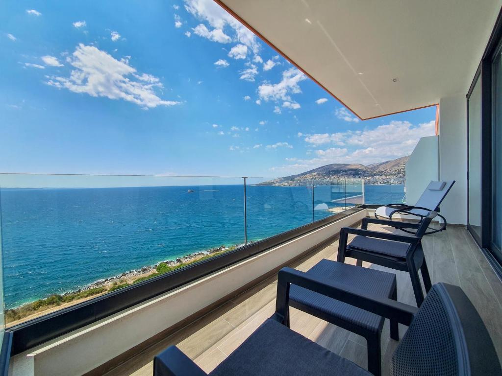 Habitación con sillas y vistas al océano. en LOOKOUT Apartments en Sarandë
