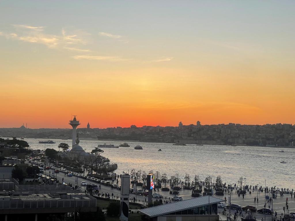 Blick auf eine Stadt mit einem Uhrturm bei Sonnenuntergang in der Unterkunft Askadar May Otel in Istanbul