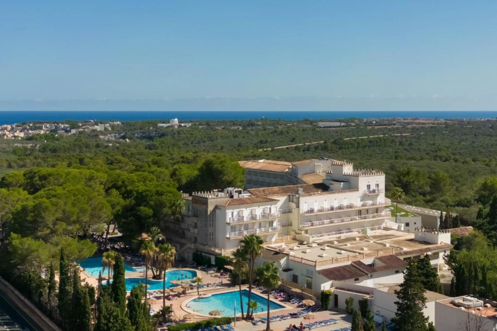 eine Luftansicht auf das Hotel und den Pool in der Unterkunft Hotel Castell dels Hams in Porto Cristo