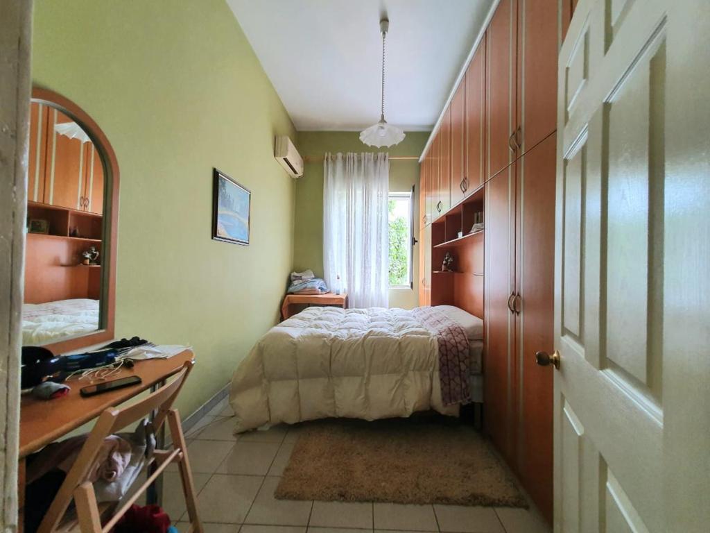 a bedroom with a bed and a desk and a window at Center Appartment in Tirana