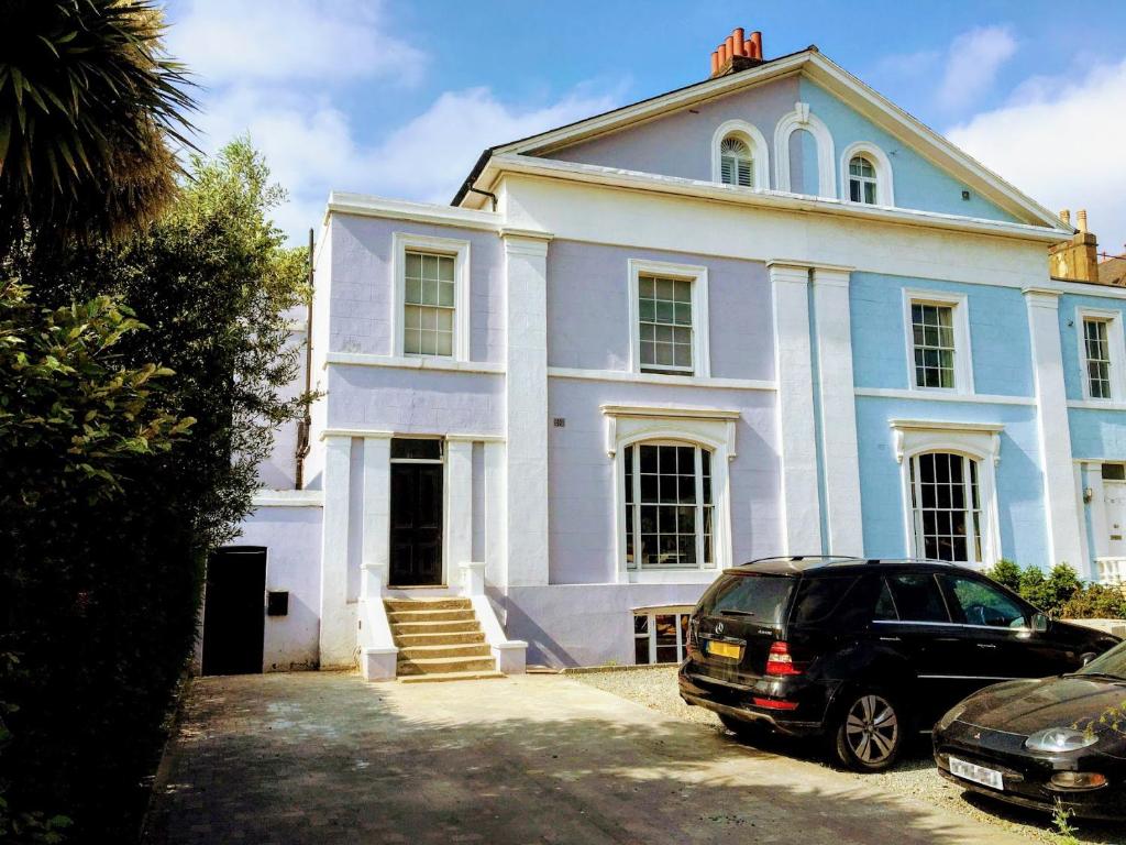 a car parked in front of a white house at Elegant & spacious parkside 2-bedroom 2-bathroom flat in period building opposite Blackheath Common - private entrance, great Greenwich location! in London