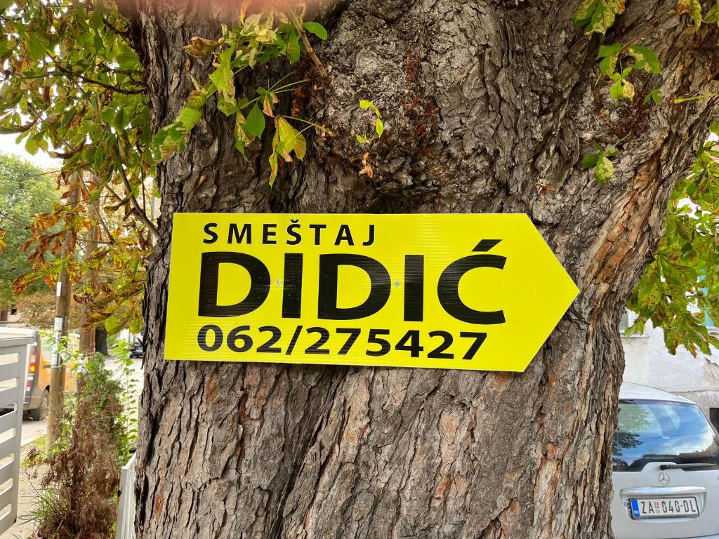 a sign on a tree that reads urgent dipidate at Smeštaj Didić in Soko Banja