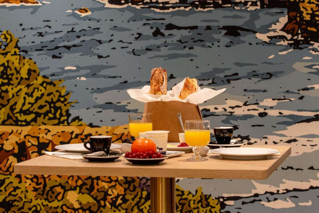 a table with a basket of bread and glasses of orange juice at Le Gamaritz in Biarritz