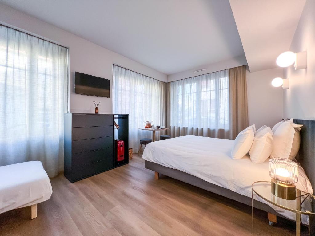 a bedroom with a large bed with white pillows at Le Gamaritz in Biarritz