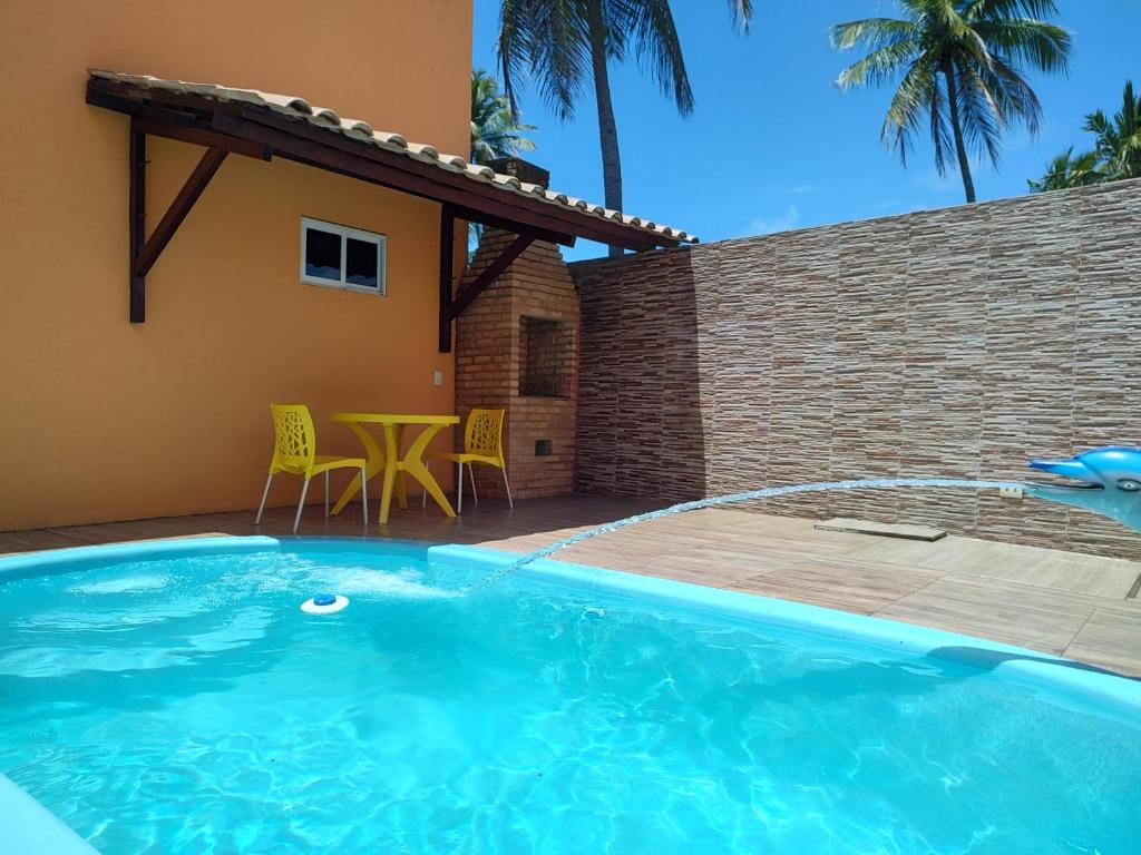 a swimming pool in front of a house at Apart. japaratinga in Japaratinga