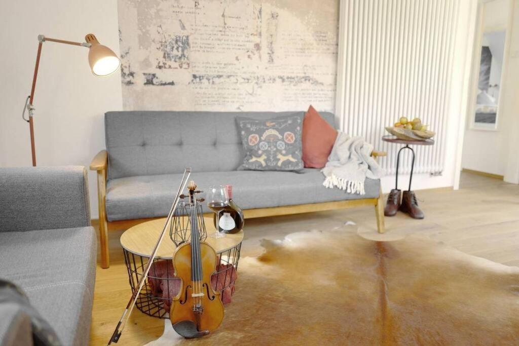un soggiorno con un divano blu e un violino di stilvolle Wohnung direkt in der City a Würzburg