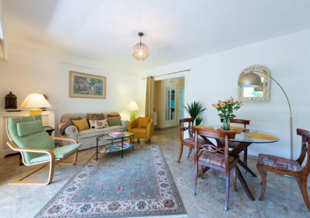 uma sala de estar com um sofá, uma mesa e cadeiras em Cannes bel appartement familial avec piscine em Cannes