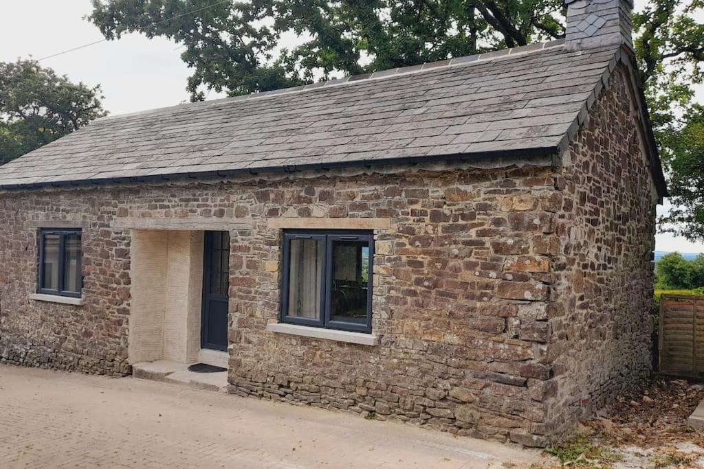 un piccolo edificio in mattoni con porta di Thornmoor Barn a Lifton