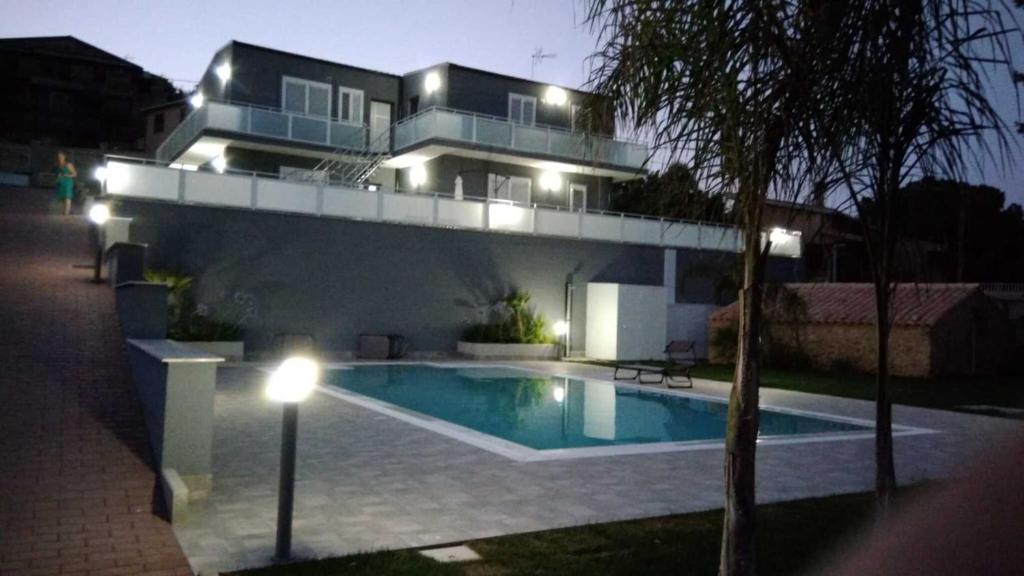 een huis met een zwembad voor een huis 's nachts bij Appartamento 2 con piscina in Caltagirone