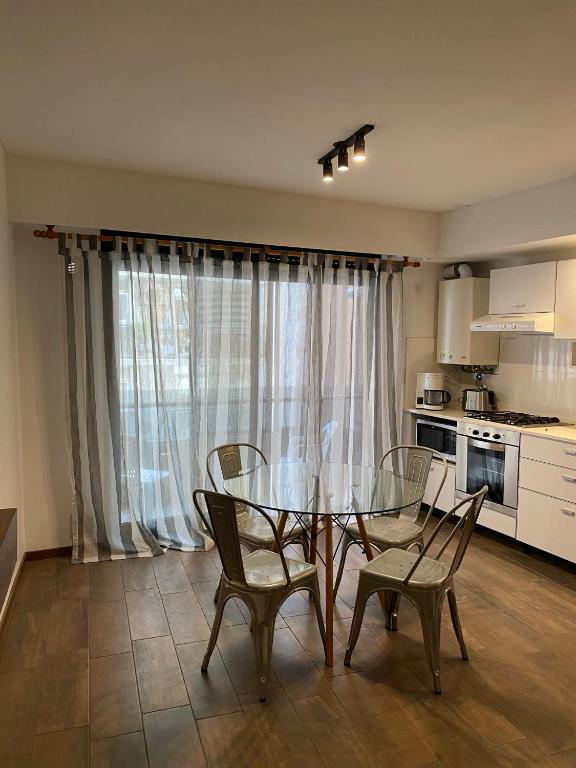 cocina con mesa de cristal y sillas en una habitación en Estudio completo en zona centro, a 200 metros del rio en Rosario