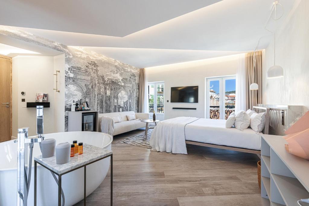 um quarto branco com uma cama grande e uma banheira em Le Dortoir Boutique Suites em Nice