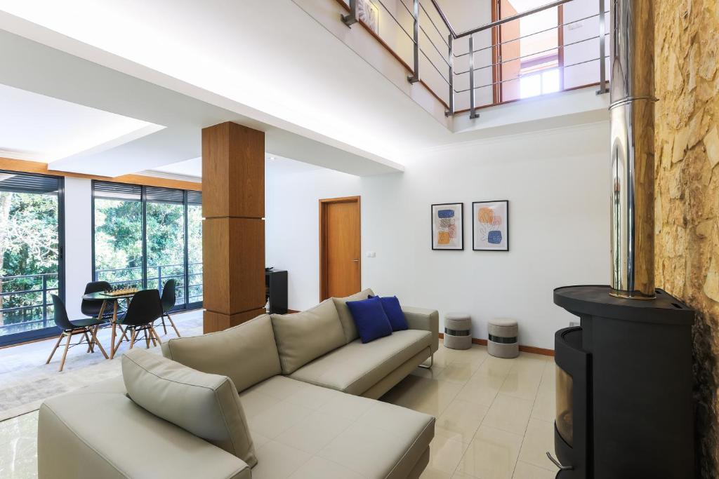 a living room with a couch and a table at A Casa da Inês in São Vicente Ferreira