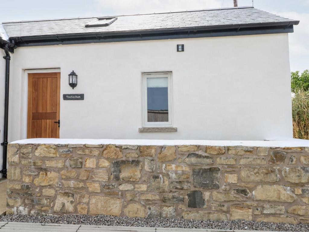 a white house with a stone wall at Trefechan - 4 Plough & Harrow in Cowbridge