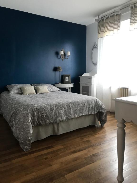 a bedroom with a bed and a blue wall at Jolie Chambre proche Centre Ville de Rennes in Rennes