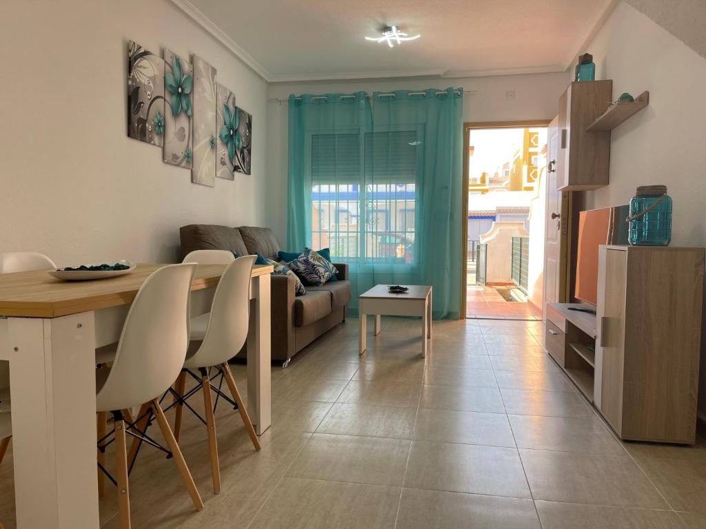 eine Küche und ein Wohnzimmer mit einem Tisch und Stühlen in der Unterkunft Adosado playa, geoda y Aguilas cerca, con barbacoa y piscina en San Juan de los terreros in San Juan de los Terreros