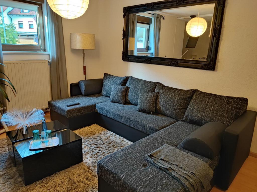 Apartment Entegast في شوبفهايم: غرفة معيشة مع أريكة ومرآة
