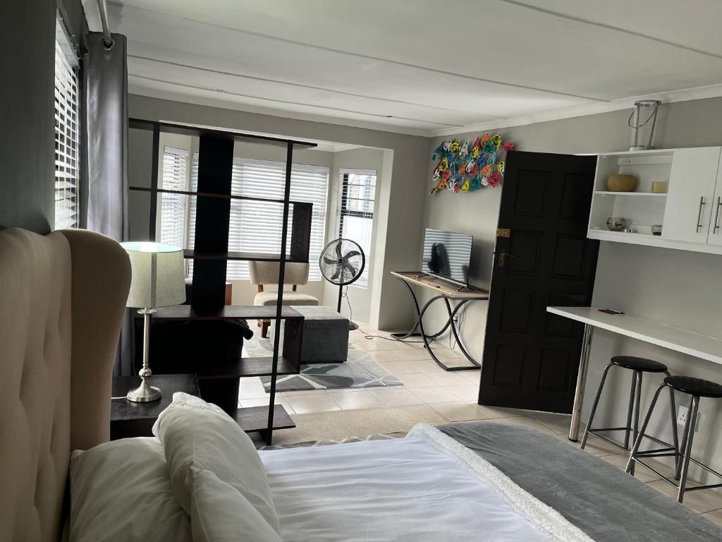 uma sala de estar com uma cama e uma cozinha em 28 on Symonds Luxstudio 4 with solar backup em George